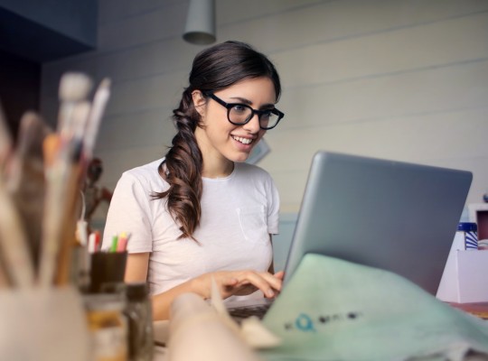 Une jeune femme souriante utilisant un ordinateur