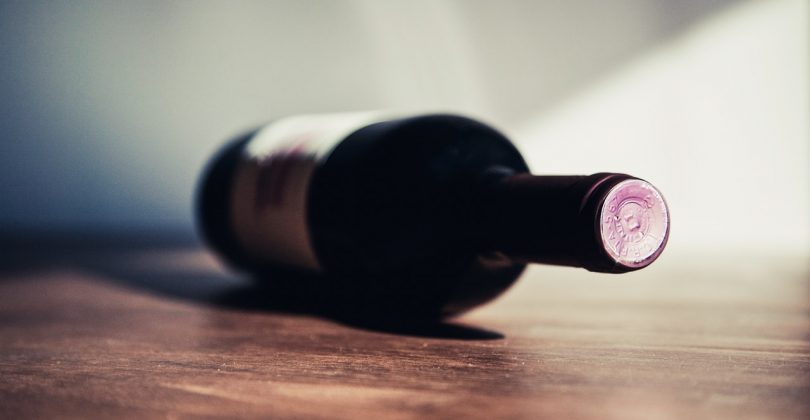 Une bouteille de vin posé sur le côté une table en bois
