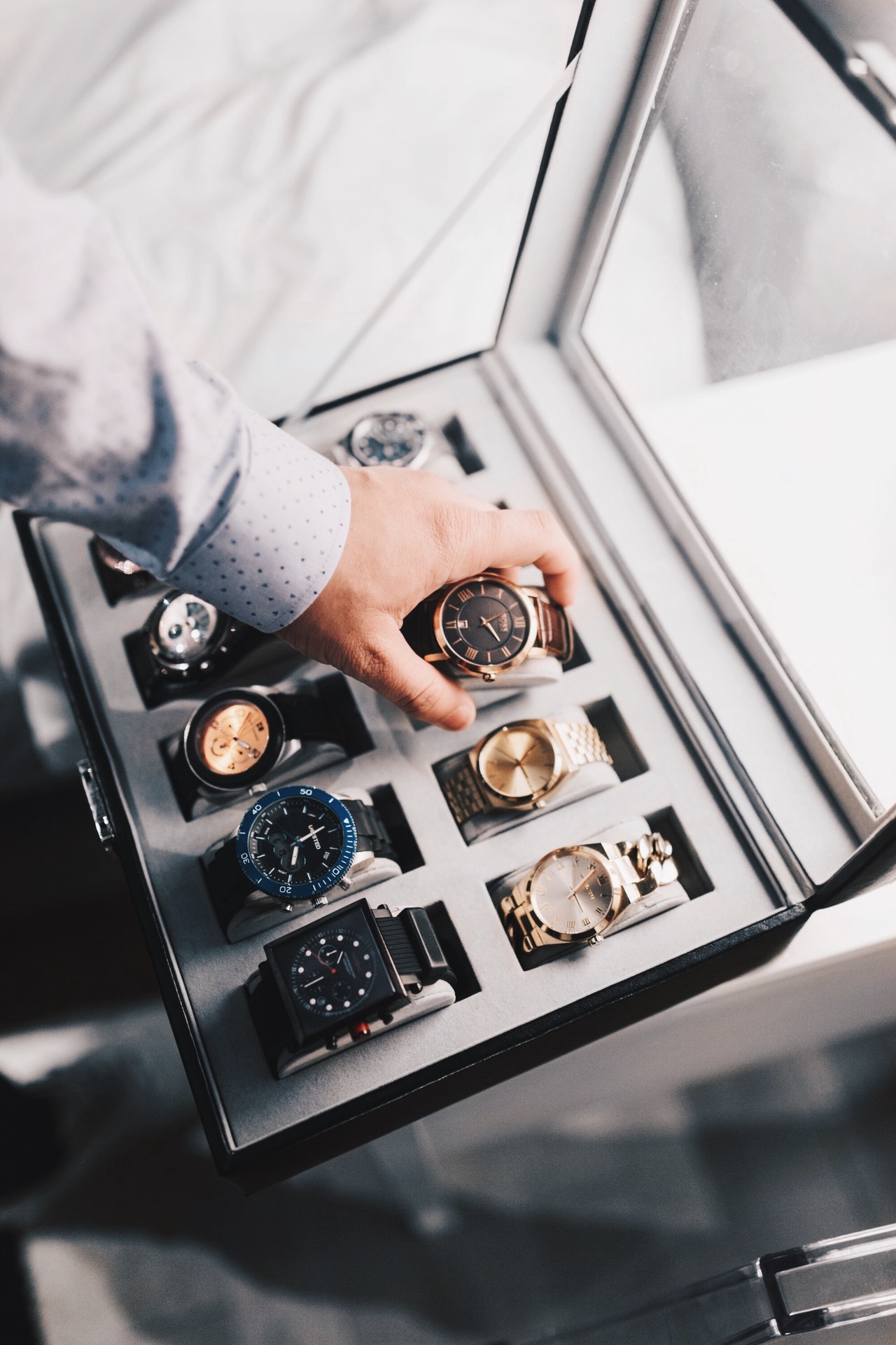 Un homme range une montre dans un coffret avec d'autres montres