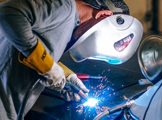 Un homme masqué en train de faire de la soudure