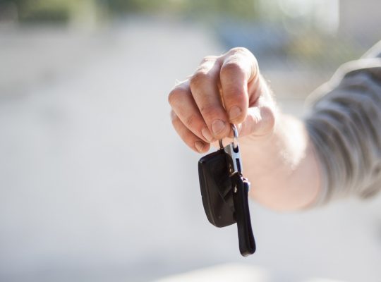 Une personne tenant dans sa main les clefs d'une voiture