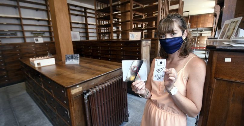 image Un agent de l'établissement dans le petit musée en train de montrer des supports de visites pour les visites guidées