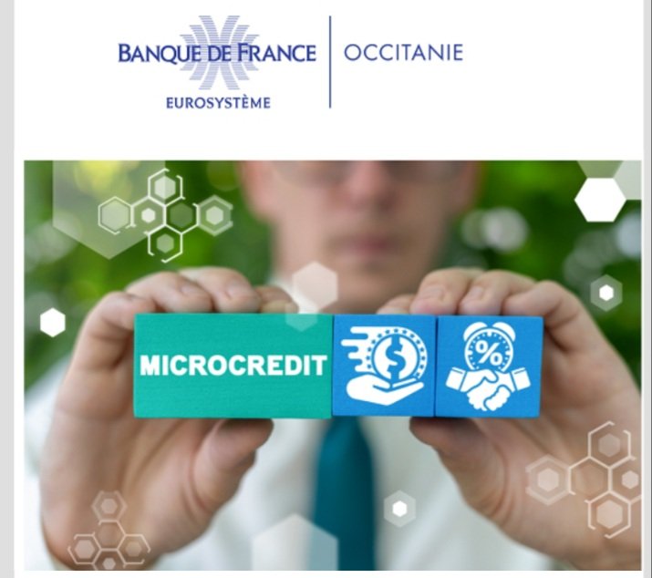 Une personne tient dans ses mains le mot "microcrédit" avec deux images symbolisant le prêt et la solidarité pour une manifestation organisée par la banque de France