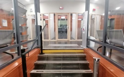 L'entrée du Crédit Municipal de Toulouse : au premier plan les escalier puis au second plan les guichets aux portes transparentes et encadrementsen bois clair