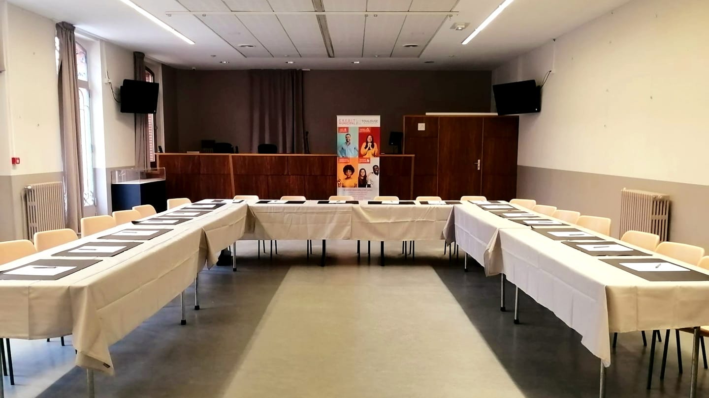L'Hôtel des ventes transformé en salle de réunion en forme de U, à l'arrière plan la tribun du commissaire-priseur devant laquelle se trouve le kakémono de l'établissement
