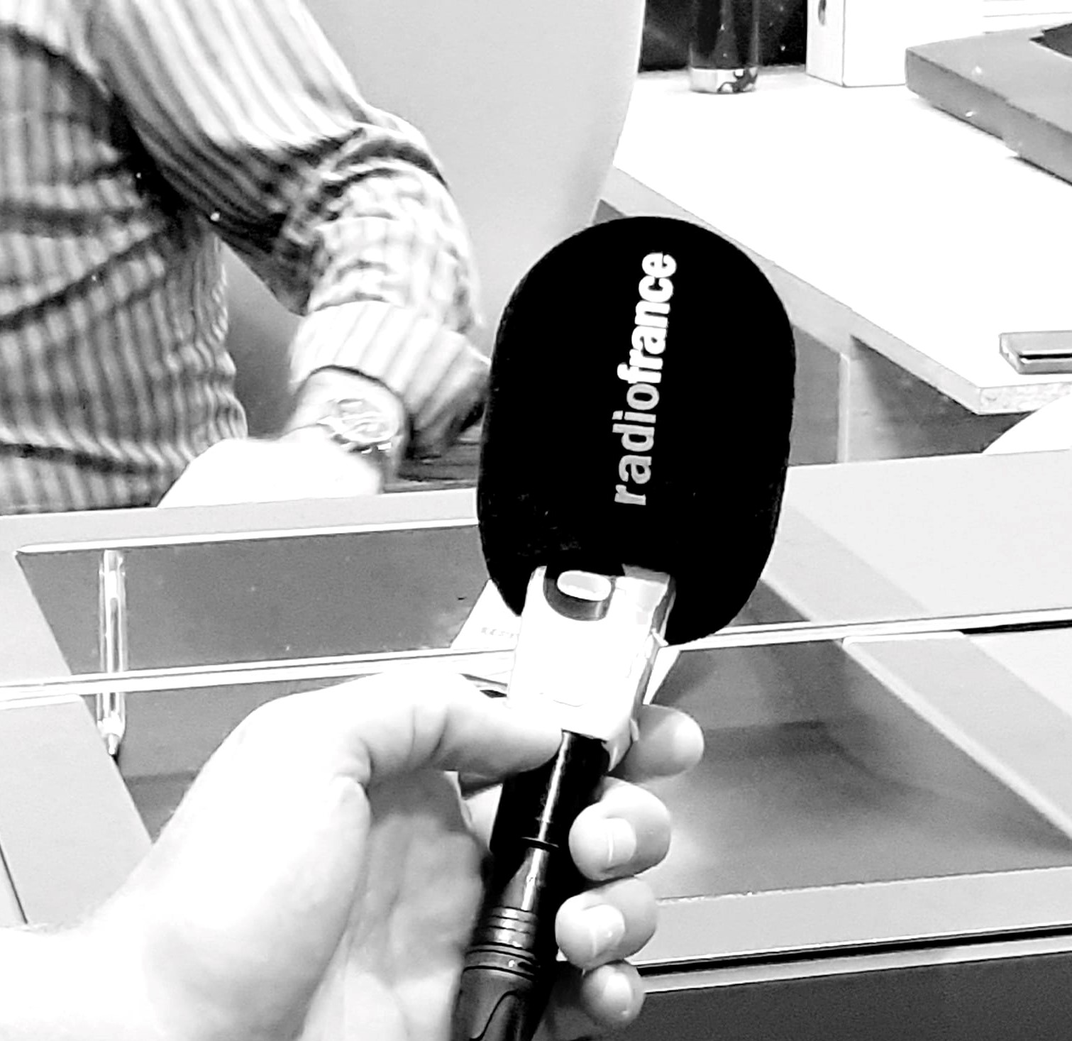 Un journaliste tenant dans ses mains un micro de radiofrance