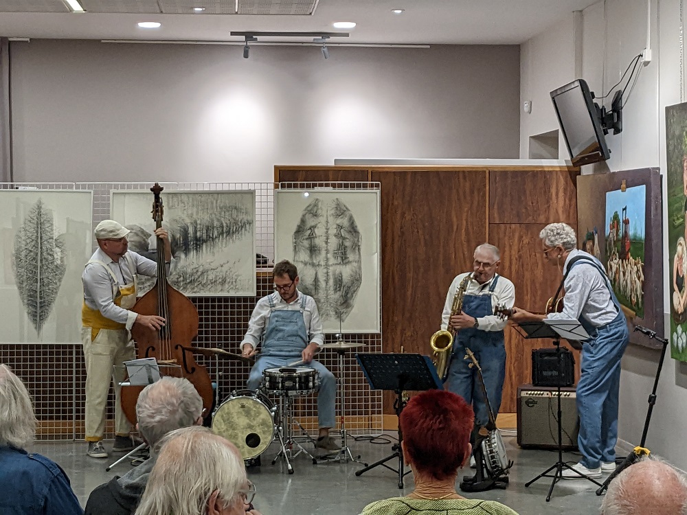 Un groupe de musique jouant un concert devant les oeuvres d'art