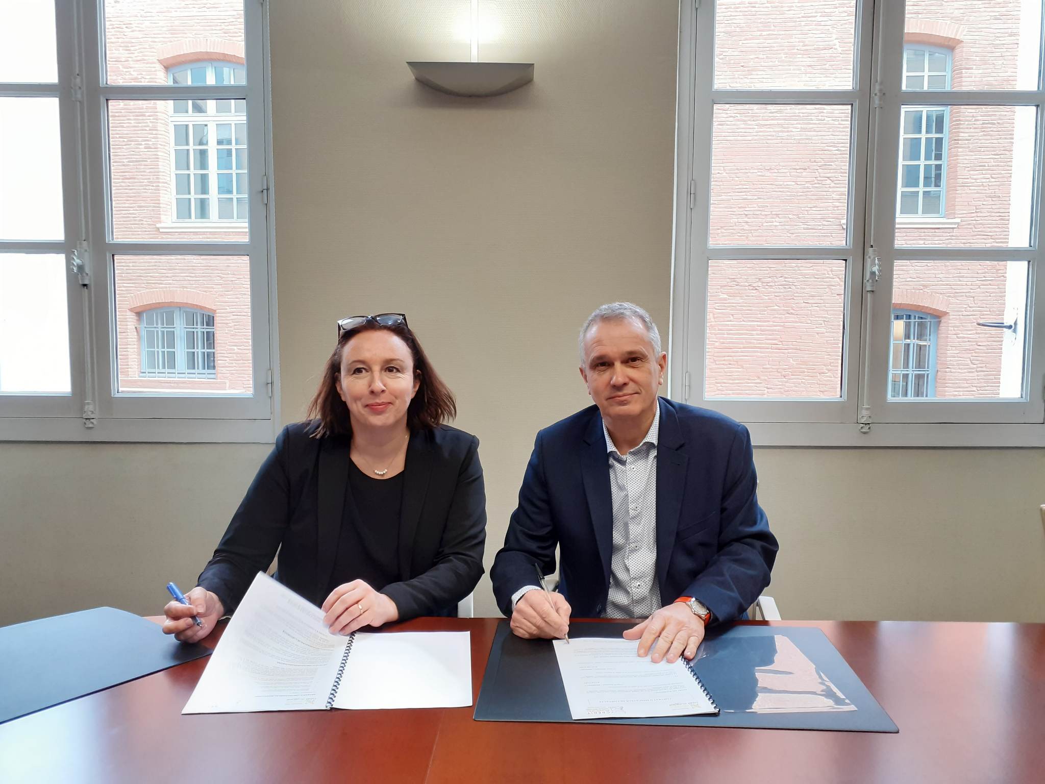 Madame Lhuir et M Paindessous respectiveent dirigeants du crédit municipal de Nimes et du Crédit municipal de Toulouse, signant une convention